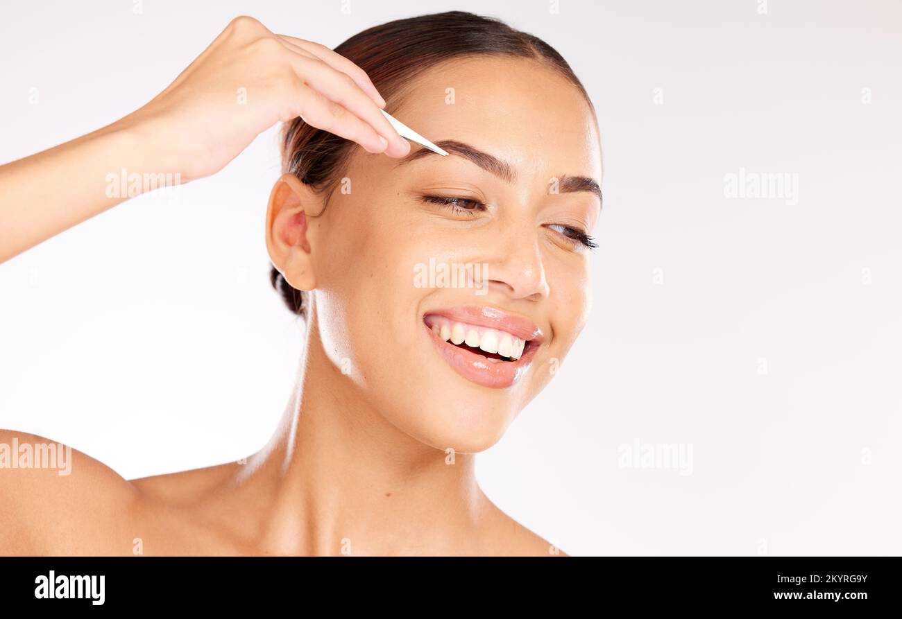 Donna, viso o pinzetta per la forma delle sopracciglia, la gestione della crescita dei capelli o la cura di sé governare su sfondo studio. Modello sorridente, felice o di bellezza con i capelli Foto Stock