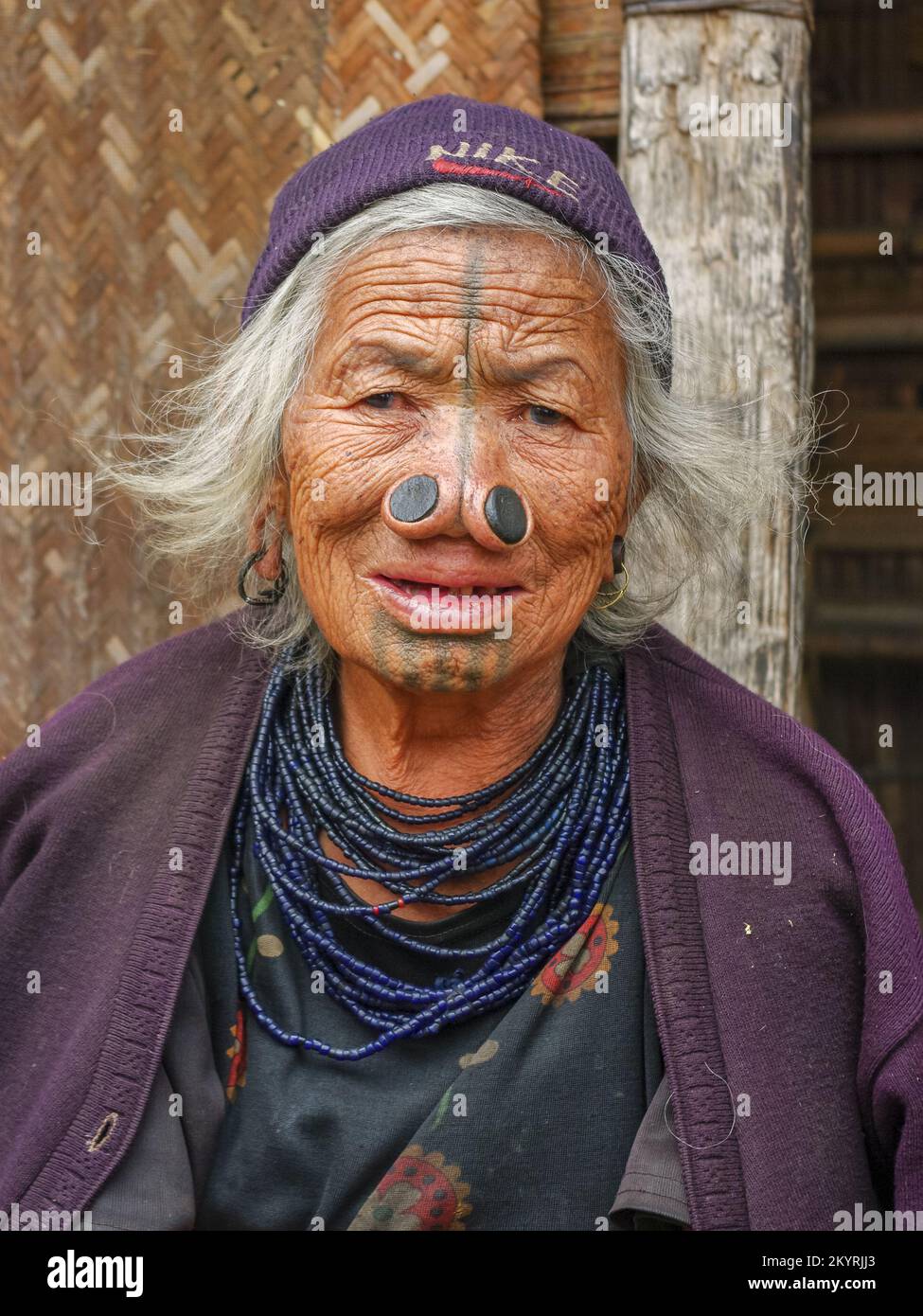 Ziro, Arunachal Pradesh, India - 02 24 2009 : Ritratto facciale di una vecchia donna tribale Apatani con tatuaggi facciali tradizionali e tappi per il naso Foto Stock