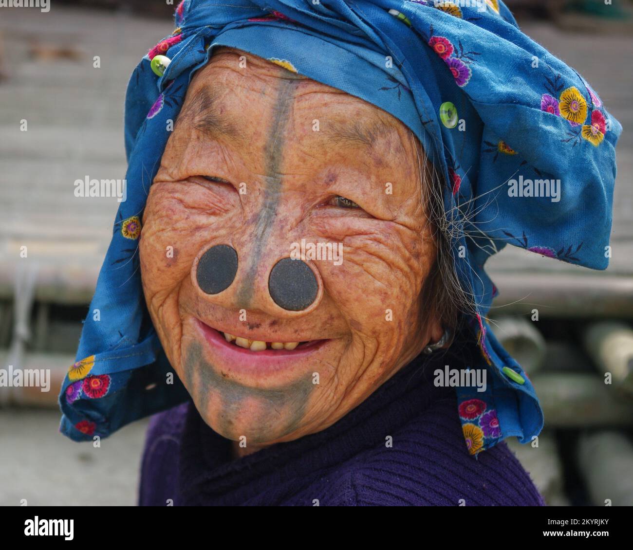 Ziro, Arunachal Pradesh, India - 03 04 2014 : Ritratto in primo piano di una donna papatana sorridente con tatuaggi facciali tradizionali e tappi per il naso Foto Stock
