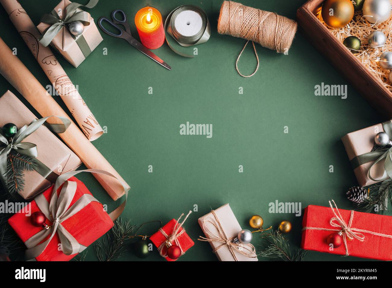 Hobby creativo. Cose per il confezionamento regali di Natale. Carta da imballaggio, forbici, nastro a spago. Fare arco a scatola regalo natale, decorato su tavola di oliva, t Foto Stock