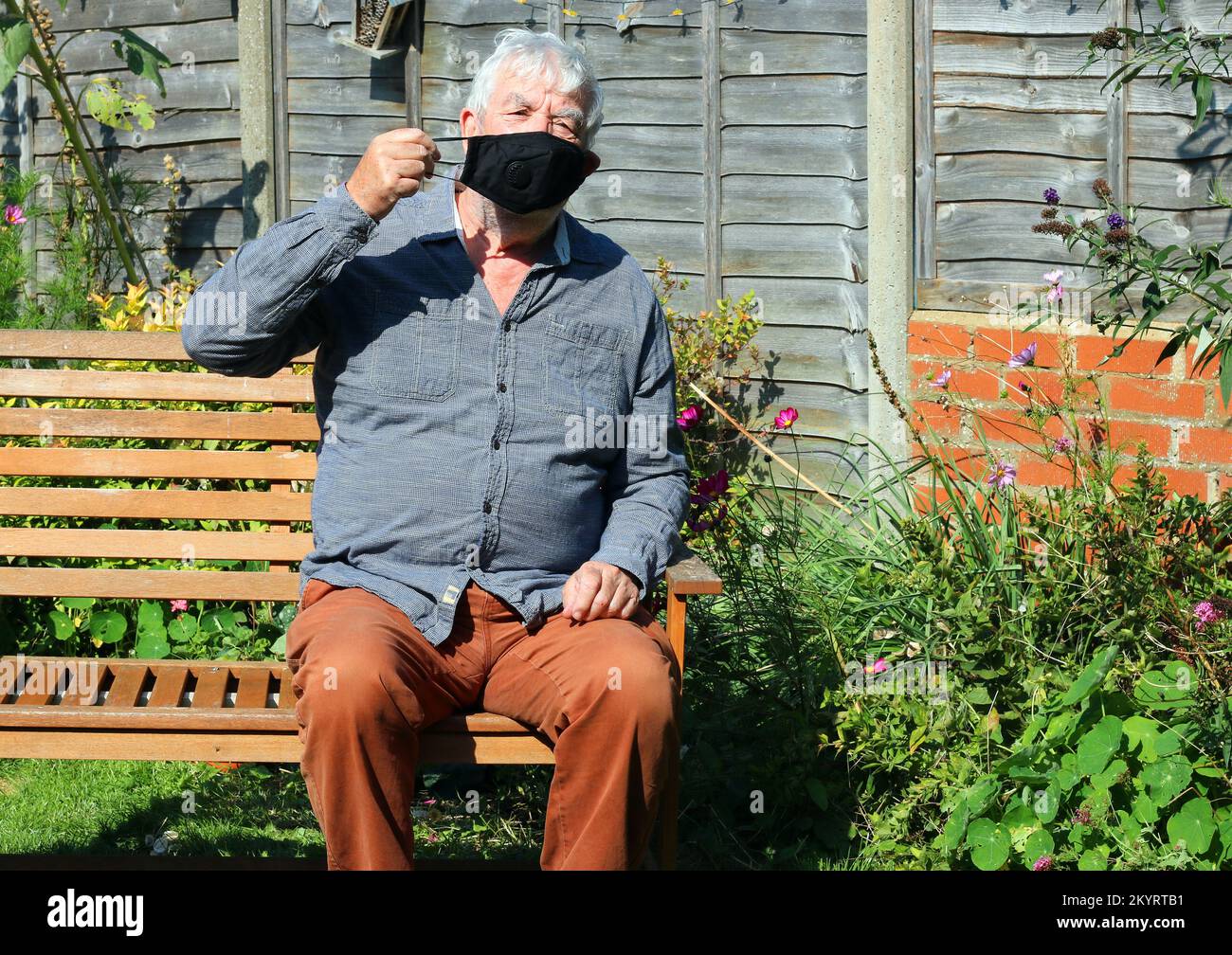 Uomo anziano o anziano che indossa una maschera per prevenire la diffusione o virus come il covid. Protezione contro l'infezione. Foto Stock
