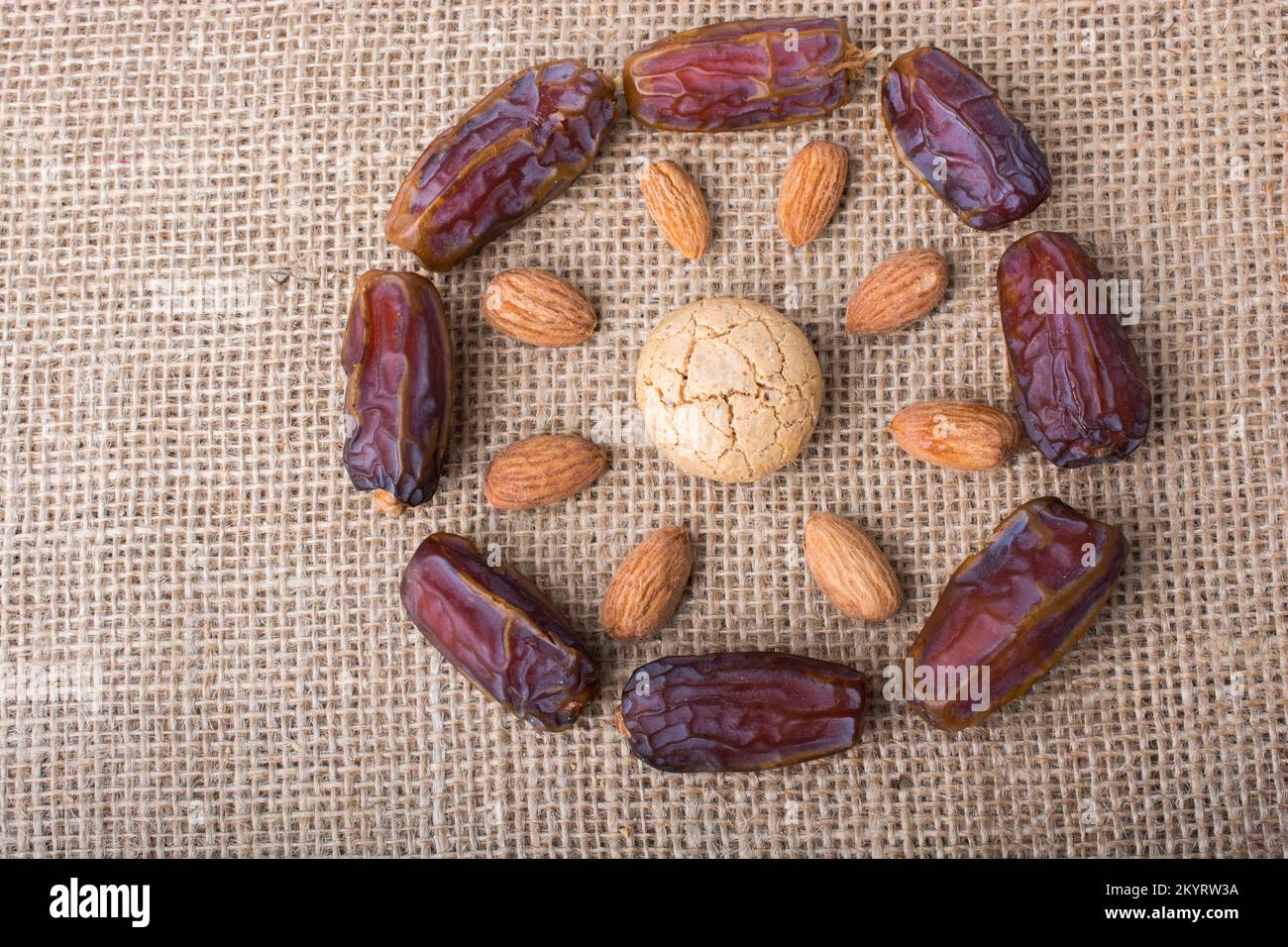 Data di frutta, mandorle e cookies costituiscono la forma di sun su tela Foto Stock