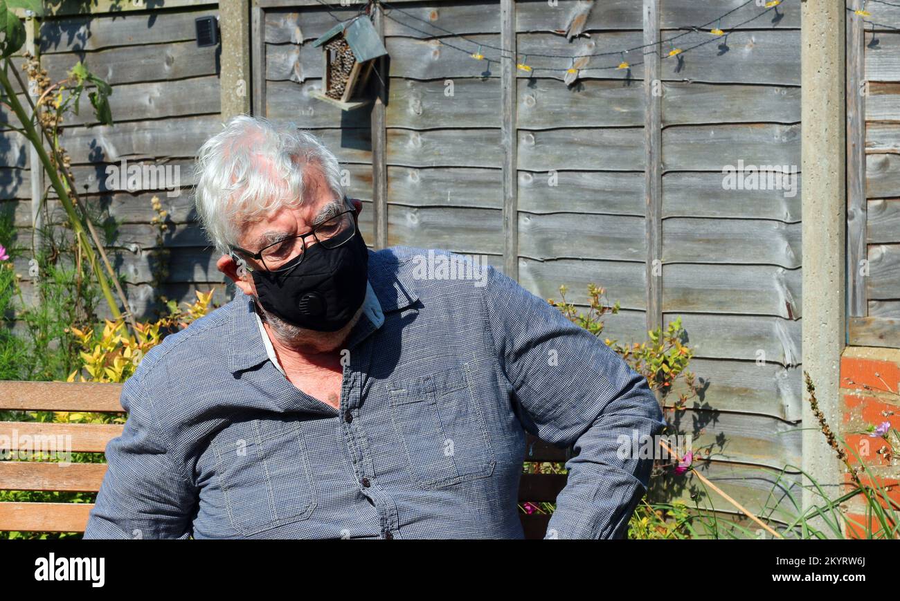 Uomo anziano o anziano che indossa una maschera per prevenire la diffusione o virus come il covid. Protezione contro l'infezione. Foto Stock