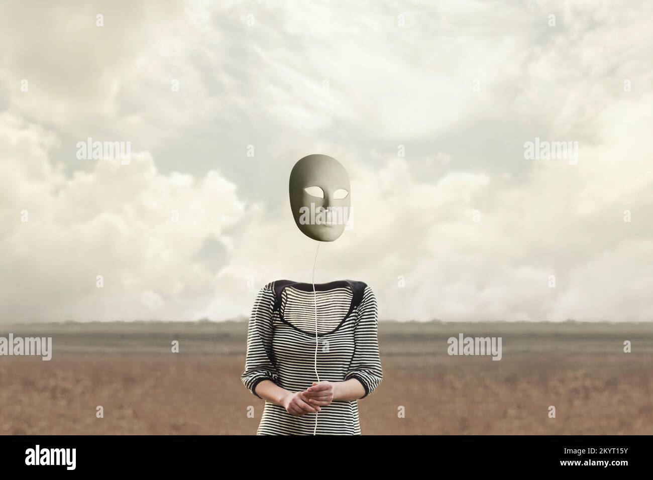 la persona surreale senza testa tiene una maschera appesa da una stringa Foto Stock