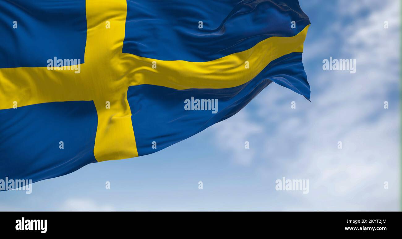 La bandiera nazionale svedese sventola nel vento. Il Regno di Svezia è un paese nordico della Scandinavia. Messa a fuoco selettiva. illustrazione 3d Foto Stock