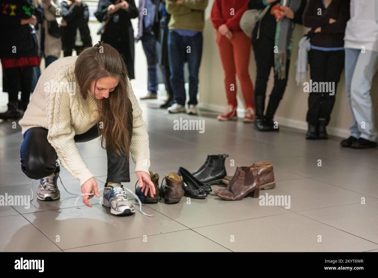 Londra, Regno Unito. 1st Dec, 2022. L'artista Yaryna Shumska con la sua opera d'arte performativa, "My Impersonal Story", che esplora le storie dei familiari e degli altri e le loro connessioni, entrando nelle loro scarpe e spostandole simbolicamente attraverso il museo. Lancio della mostra al Migration Museum di Londra. Siamo tutti collegati è una mostra di opere di sei artisti ucraini, tutti affiliati alla Lviv National Academy of Arts (LNAM), con il tema comune della migrazione e le cose che ci collegano tutti. Credit: Imageplotter/Alamy Live News Foto Stock