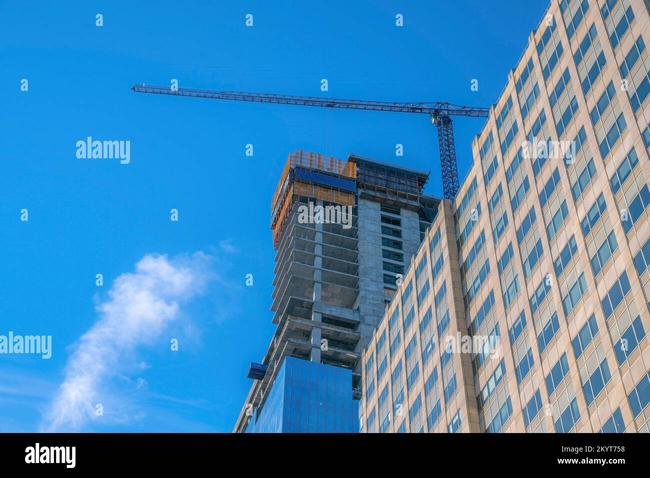 Appartamento accanto ad un edificio incompiuto a Austin Texas contro il cielo blu. Una gru da cantiere può anche essere visto dietro l'edificio residenziale su Thi Foto Stock