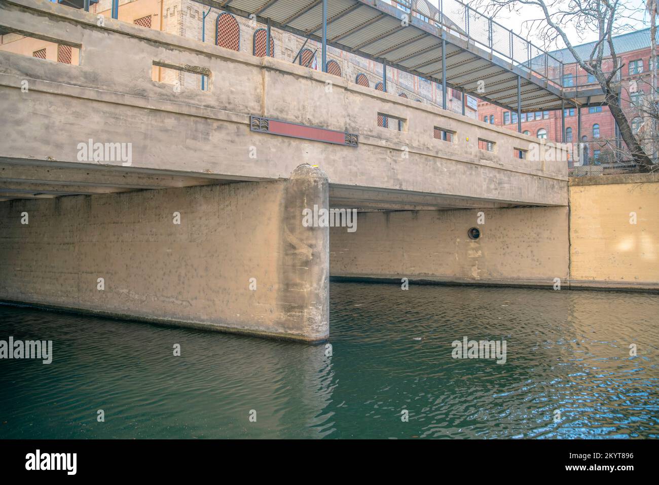 Ponte di cemento su un canale presso la famosa passeggiata sul fiume San Antonio in Texas. Vista sulla popolare destinazione turistica o attrazione con acqua increspata Foto Stock