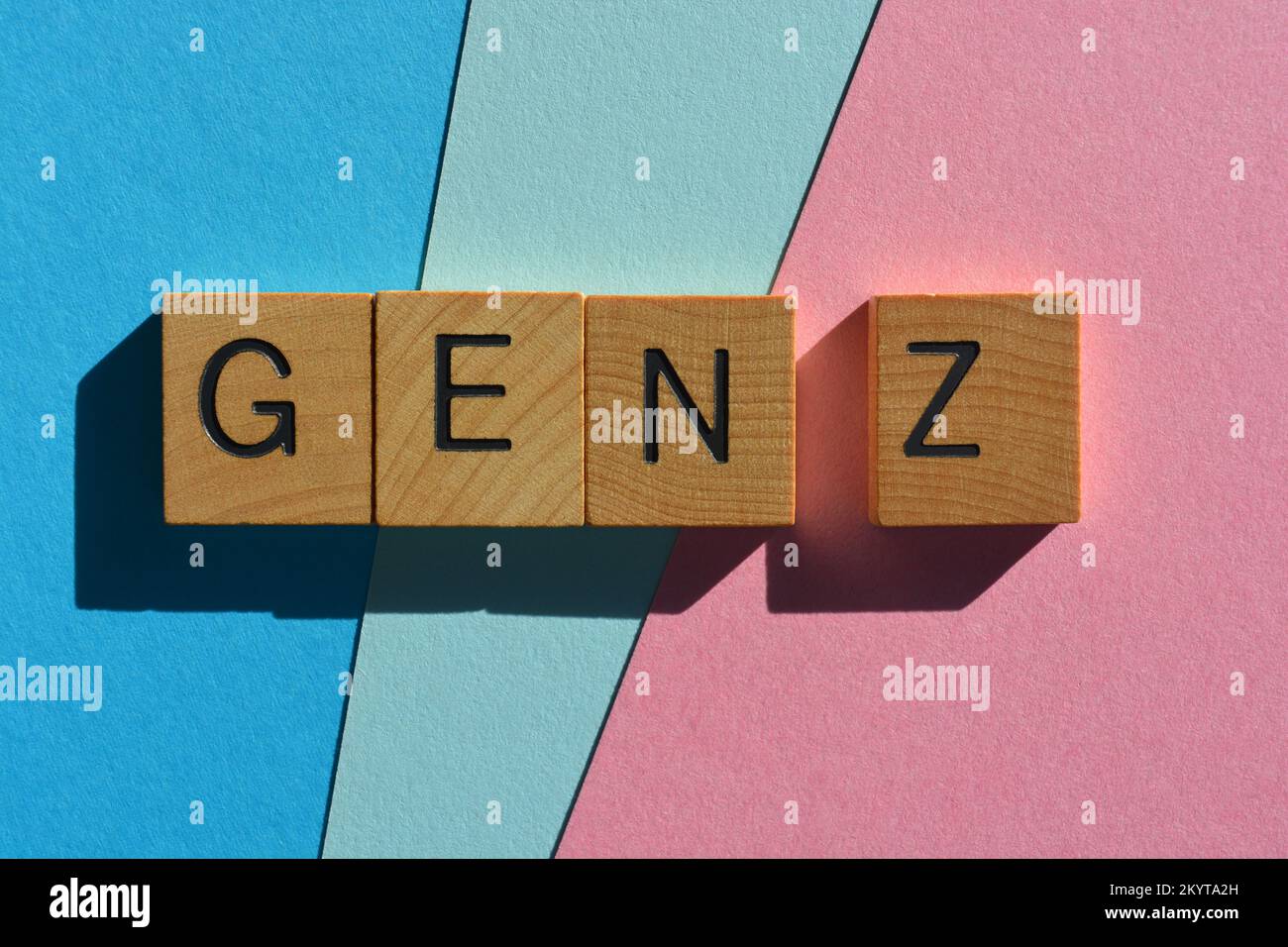 Gen Z, abbreviazione di generazione Z in lettere alfabetiche di legno isolate su sfondo rosa e blu Foto Stock