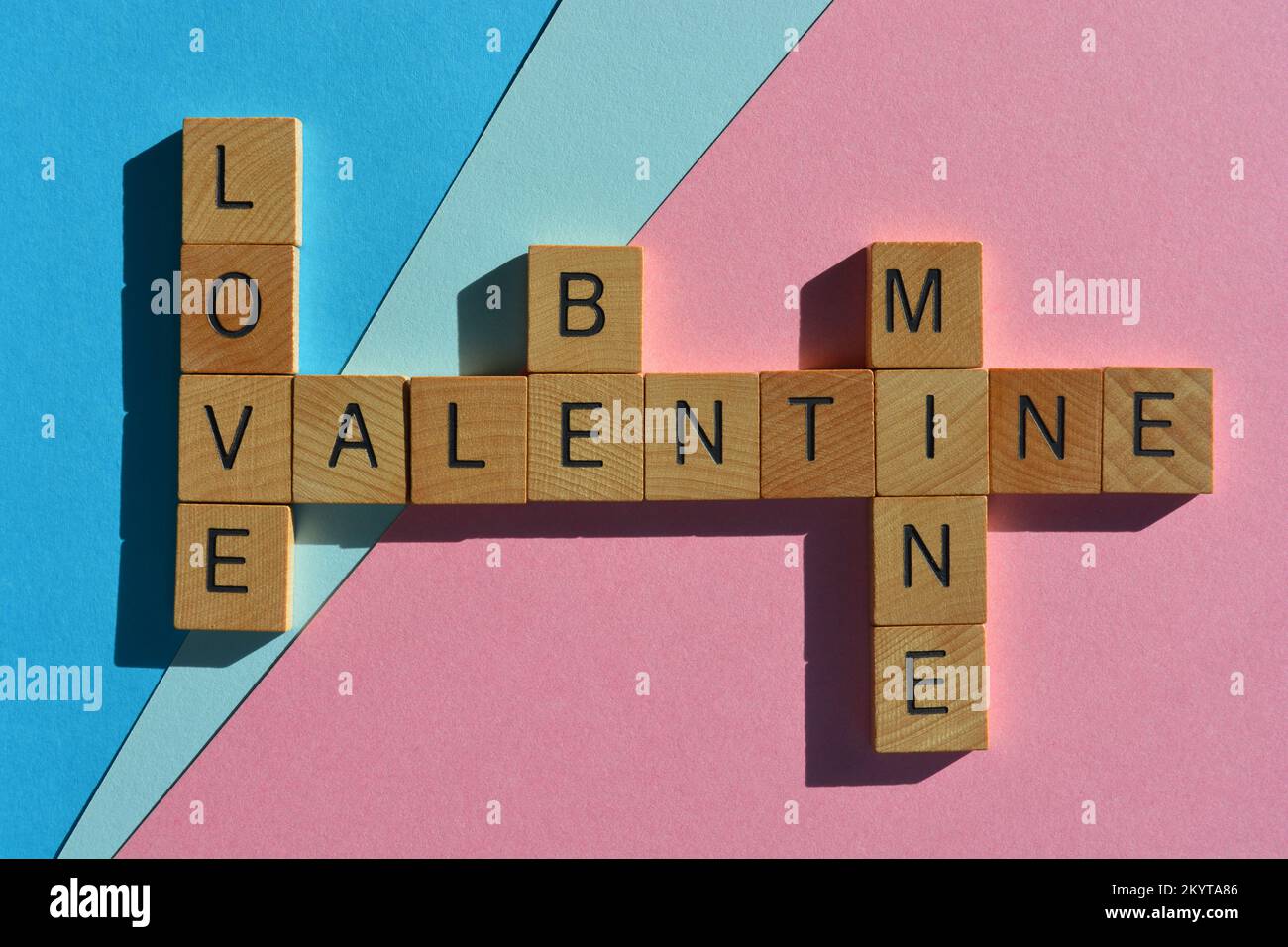 Amore sia Mine San Valentino, parole in lettere di alfabeto di legno in forma di croce isolato su sfondo rosa e blu Foto Stock