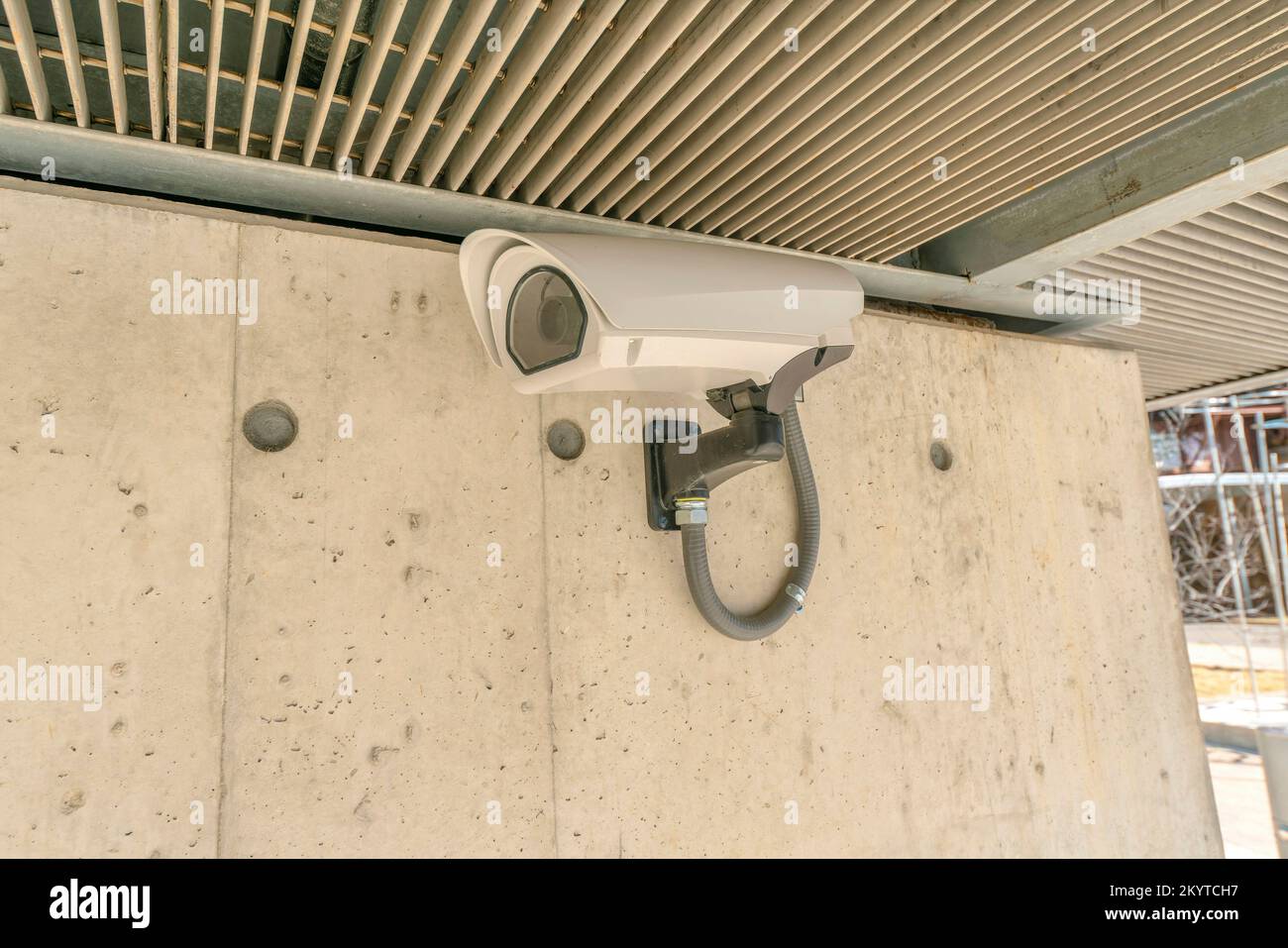 Austin, Texas- primo piano di una telecamera di sicurezza montata a parete. Primo piano di una telecamera TVCC per montaggio a parete contro la parete in cemento e il soffitto in metallo. Foto Stock