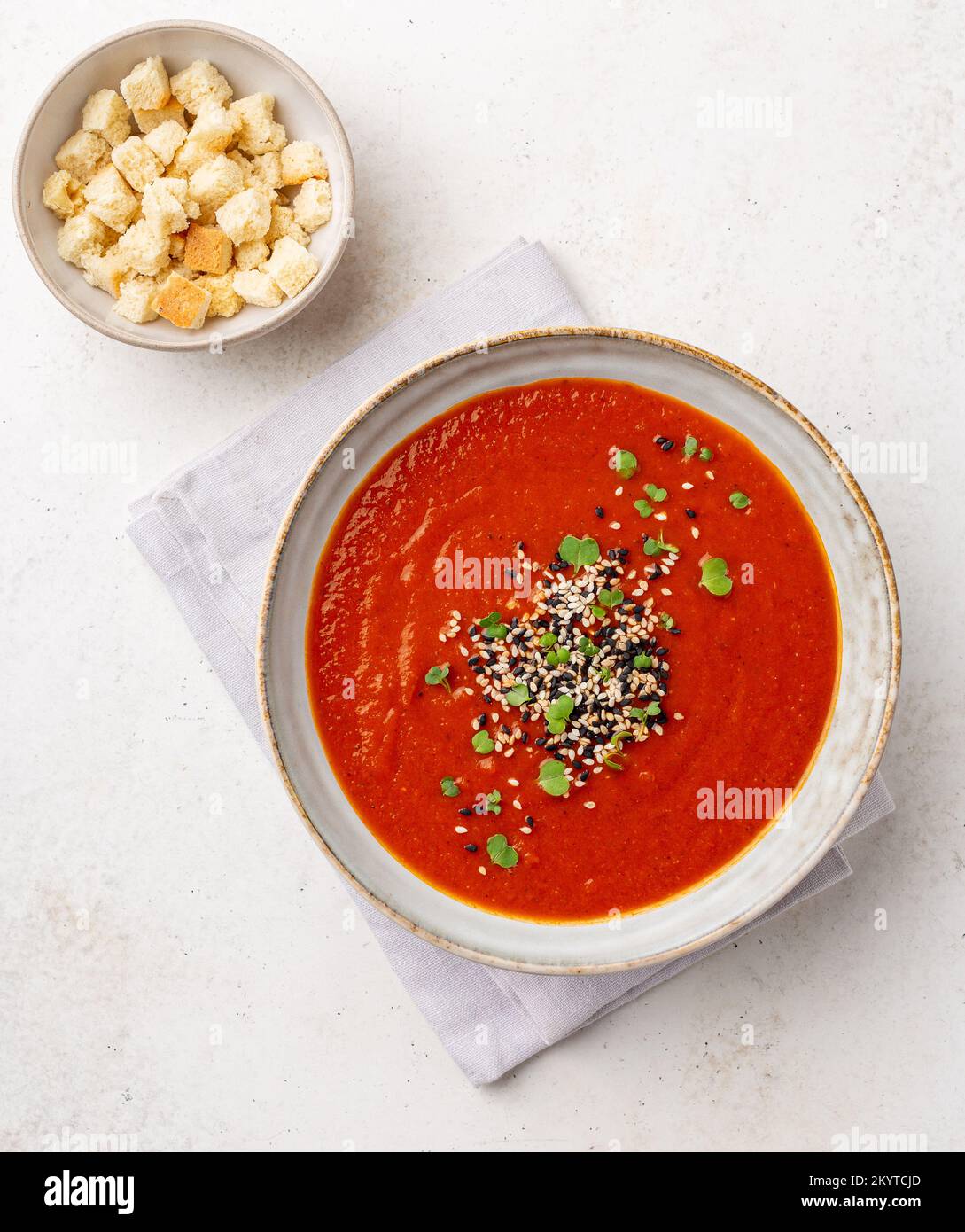 Purea zuppa di pomodoro piccante guarnita con semi di sesamo e micro verdi, vista dall'alto Foto Stock