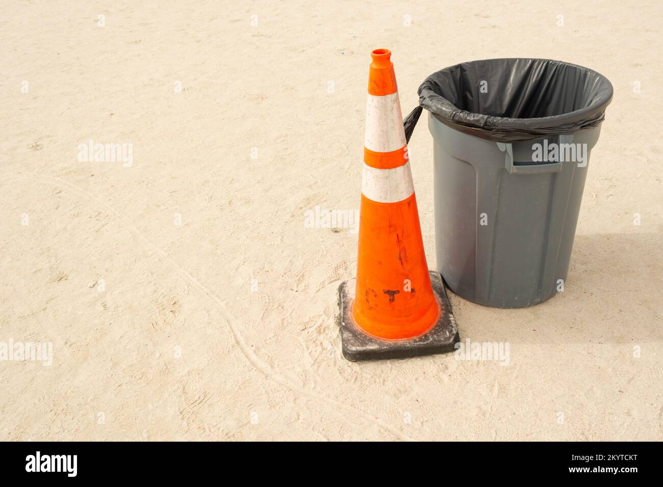 spiaggia pulita con bidone grigio e cono arancione Foto Stock