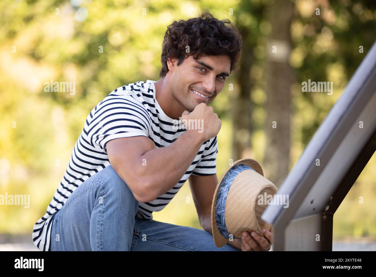 profilo vista laterale ritratto di giovane uomo che tiene il cappello Foto Stock