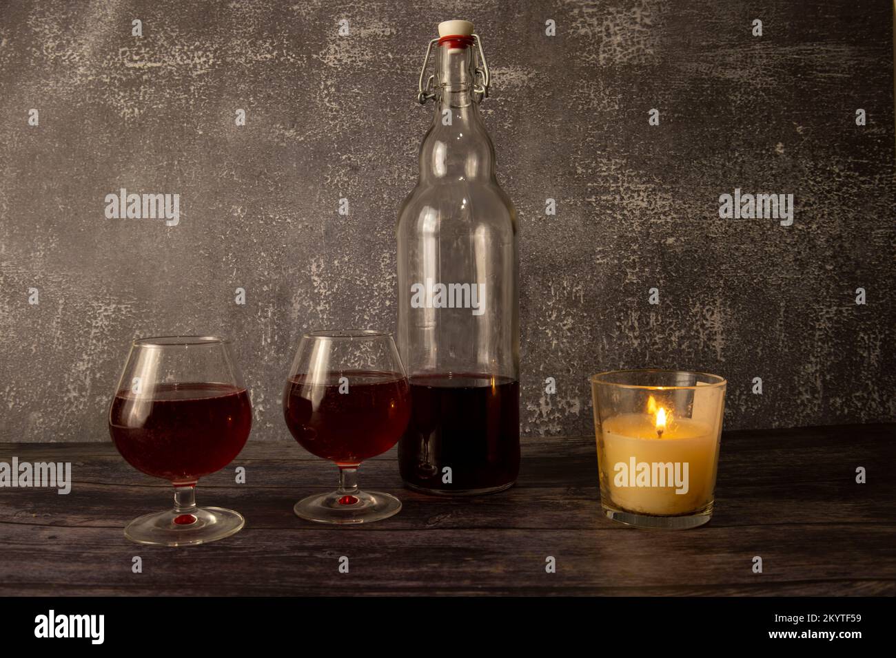 Una bottiglia di vino con bicchieri a lume di candela. Foto Stock
