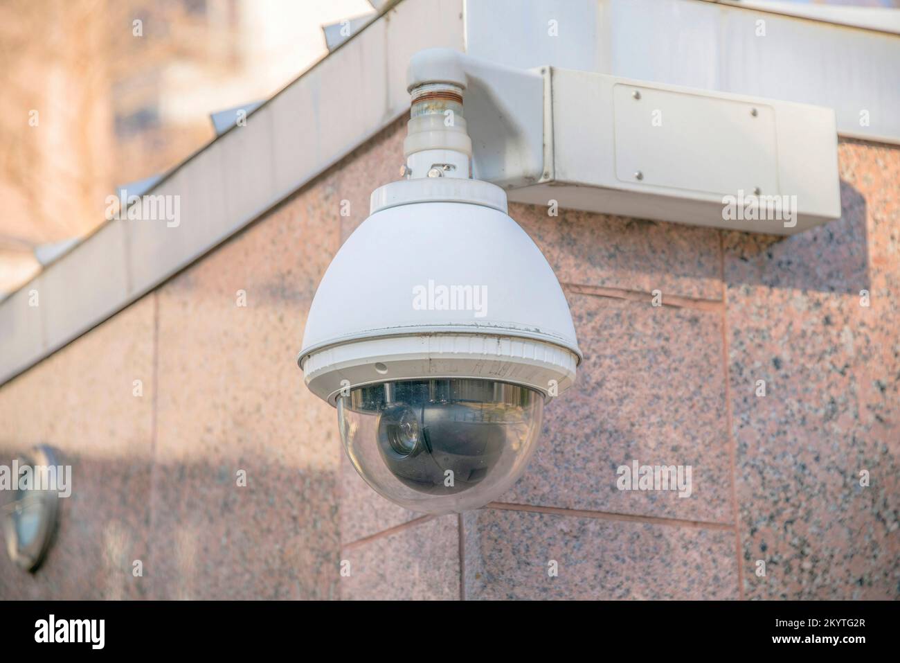 Austin, Texas- primo piano di una cupola CCTV all'angolo di un edificio. Telecamera di sorveglianza contro il rivestimento in granito dell'edificio. Foto Stock