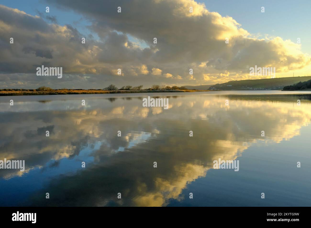 Nel tardo pomeriggio sole invernale e nuvole sopra le acque cristalline di Slapton Ley, Start Bay, South Devon, UK Foto Stock