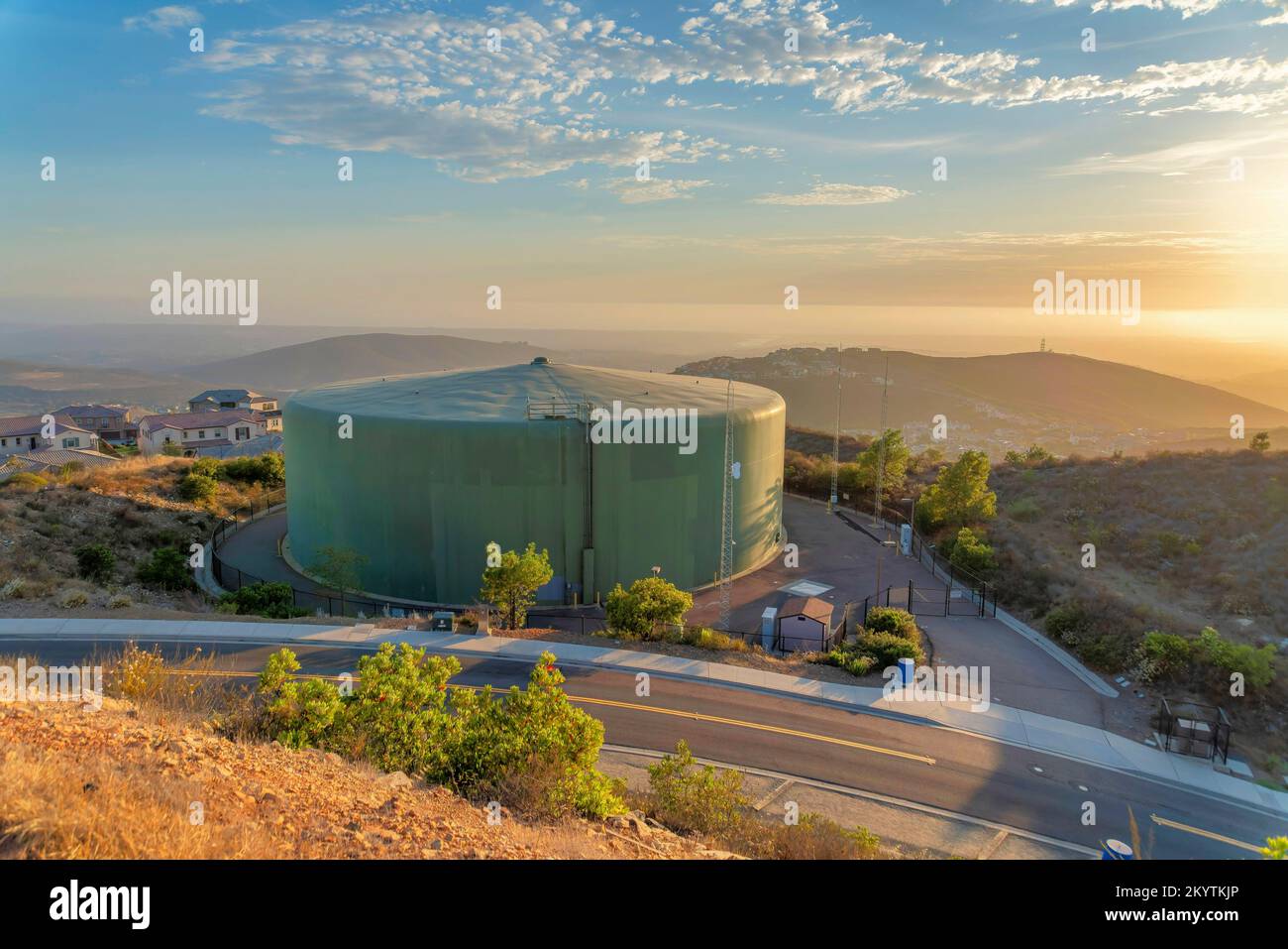 Serbatoio di conservazione dell'acqua vicino all'autostrada di San Diego, California meridionale. Grande serbatoio di acqua comunale vicino alla zona residenziale contro montagne e. Foto Stock