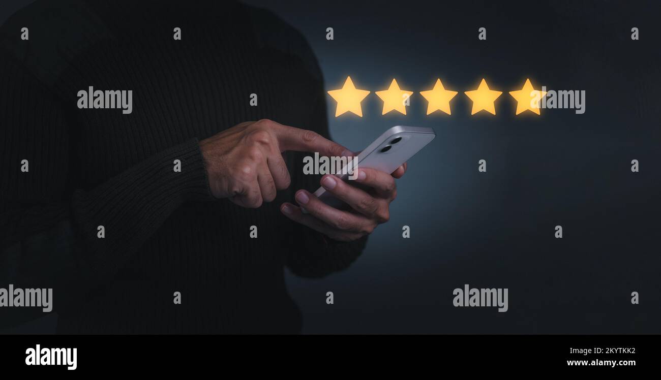 Concetto aziendale. Mano dell'uomo del cliente che preme sullo schermo dello smartphone con l'icona dorata di feedback a cinque stelle e il livello di stampa eccellente posizione per dare b Foto Stock