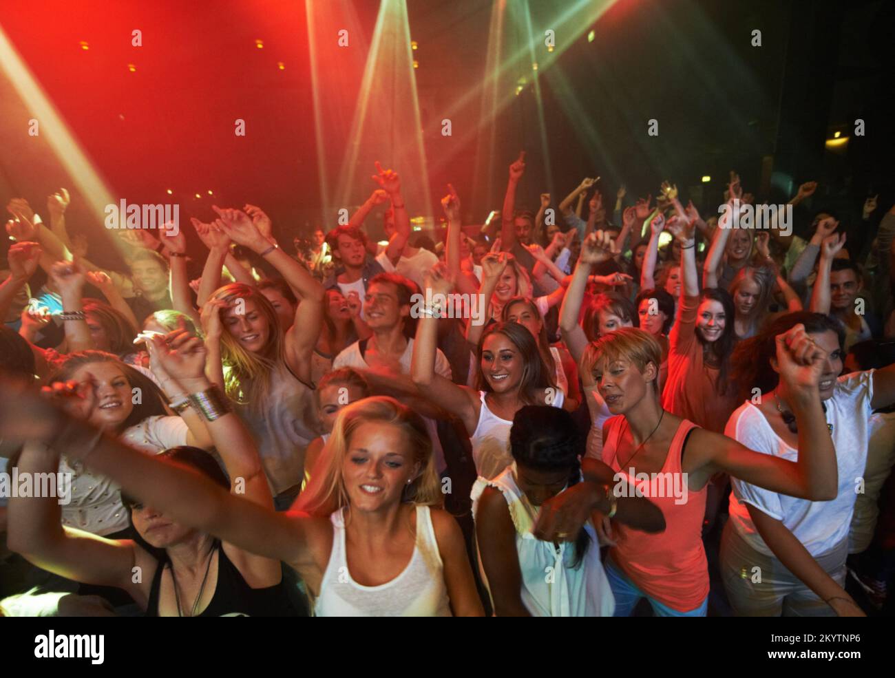 Musica da concerto, rock e folla di persone con luci da discoteca per ballare, esibirsi e cantare insieme in festival psichedelico. Night club Foto Stock