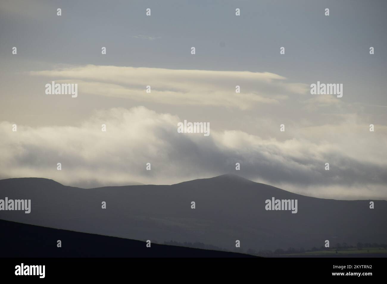 Viste distanti dalla cima di una collina del Galles evidenziano il cielo ampio e i paesaggi nuvolosi e le montagne lontane. Foto Stock