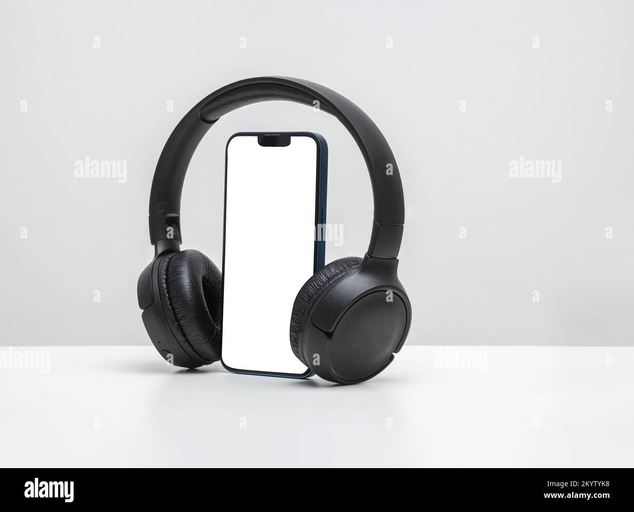 Smartphone con cuffie bluetooth con schermo bianco su sfondo neon blu, per mockup e logo Foto Stock