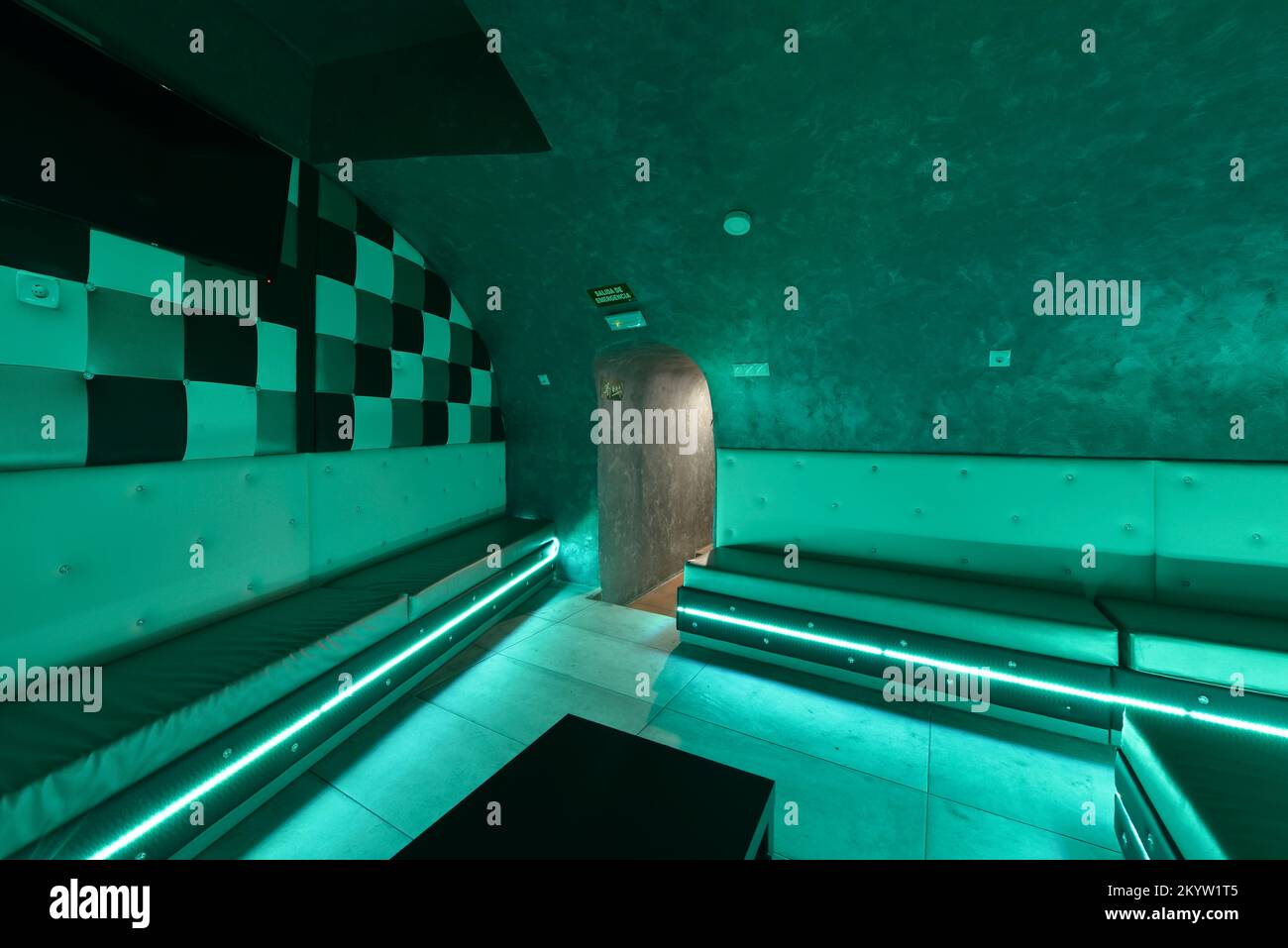 Sala da discoteca sotterranea con illuminazione a LED e poltrone alle pareti rivestite in skay bianco Foto Stock