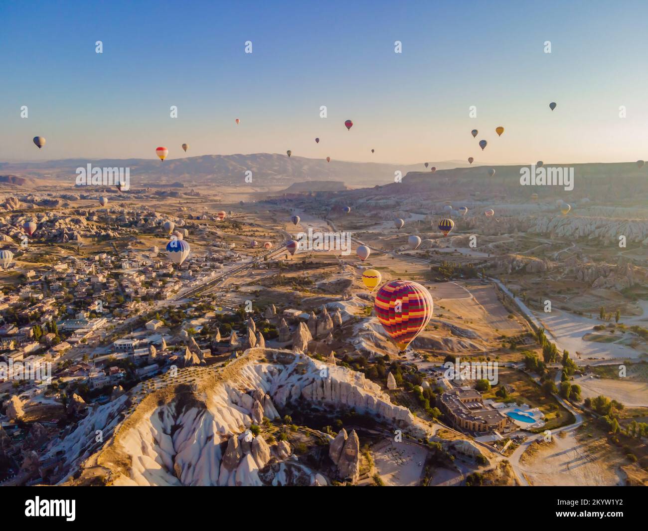 Coloratissime mongolfiere che volano nella valle dei camini delle fate a Nevsehir, Goreme, Cappadocia Turchia. Spettacolare vista panoramica del drone Foto Stock