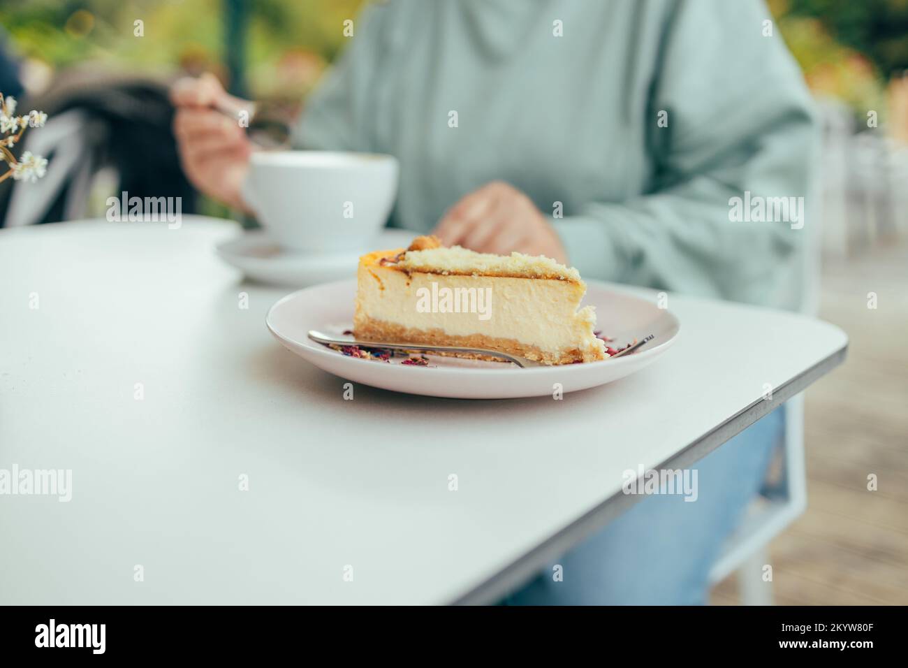 Donna mani mangiare cheesecake mentre fare colazione in caffè all'aperto, tempo libero, cibo e bevande, persone e concetto di stile di vita Foto Stock