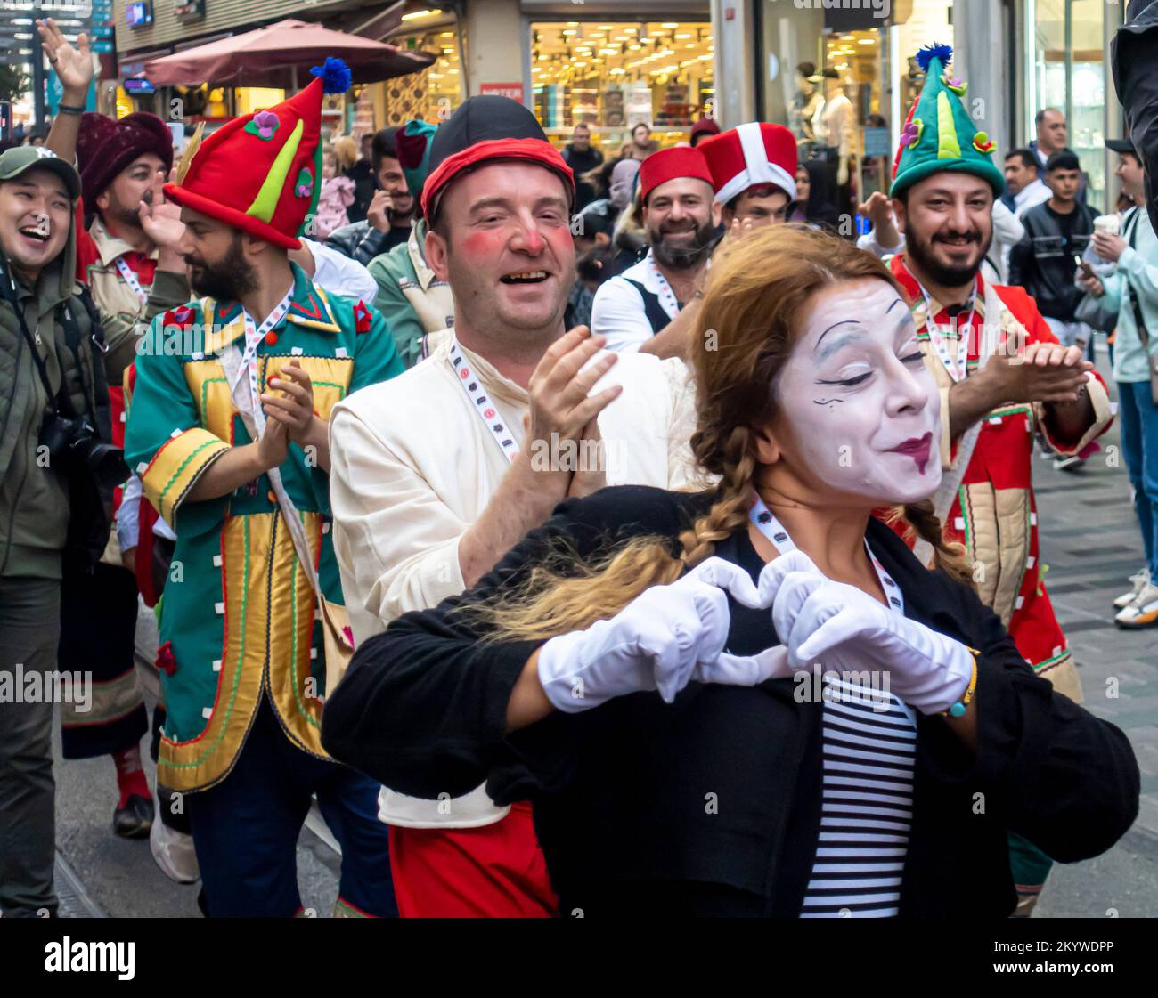 Istanbul culture: Gruppo di artisti di strada memes in make-up, con strumenti musicali che ballano lungo la strada Istiklal in mezzo alla folla. Turchia Foto Stock