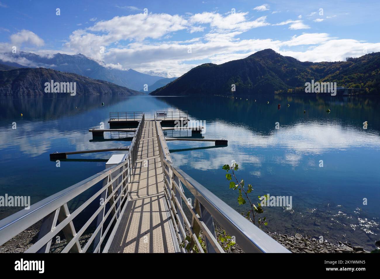 molo nel lago di Serre Poncion, Alpi del Sud, Francia con specchio riflesso delle montagne e delle nuvole Foto Stock