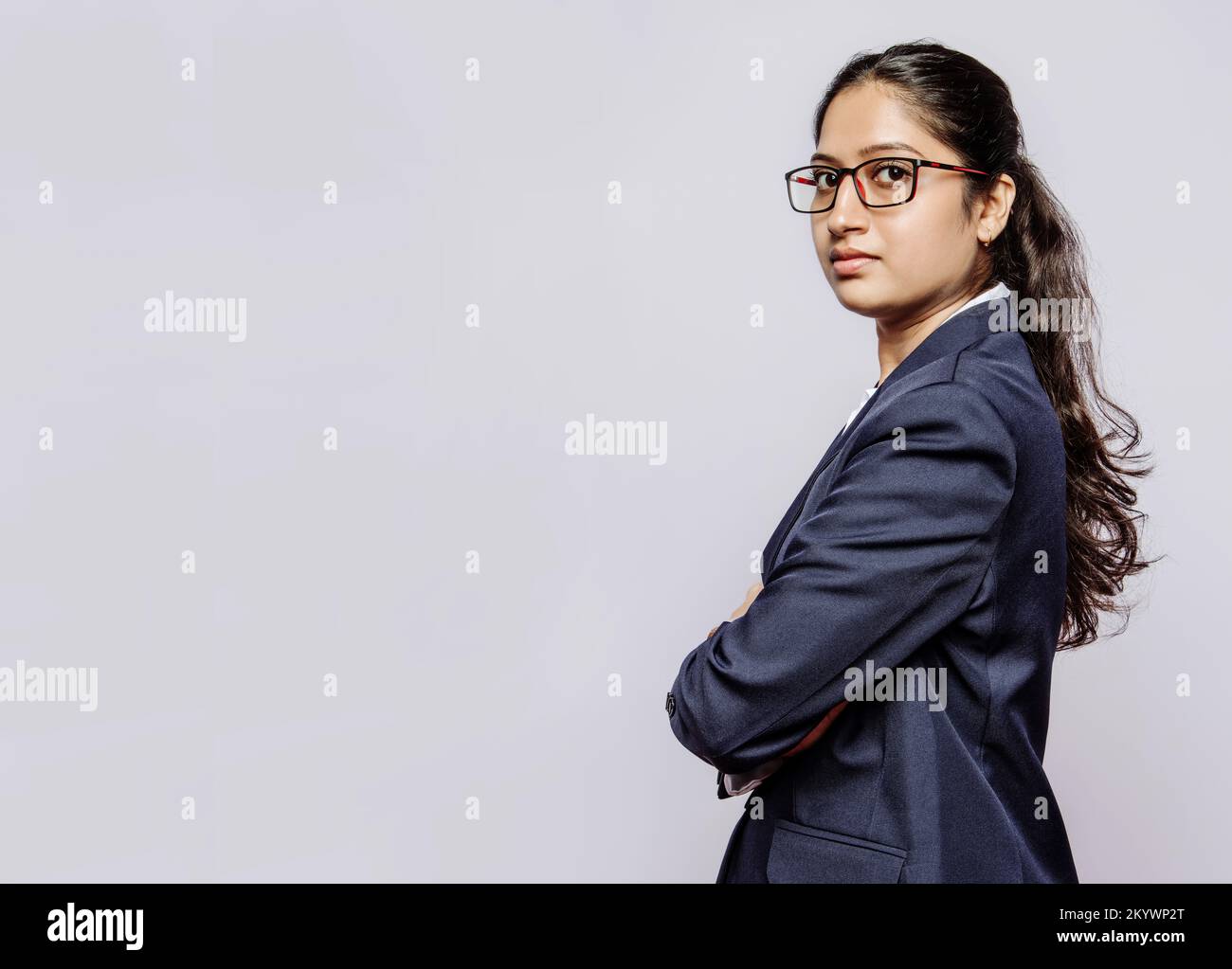 Vista laterale di una ragazza del college in mani blu vestito piegato e specifiche Foto Stock