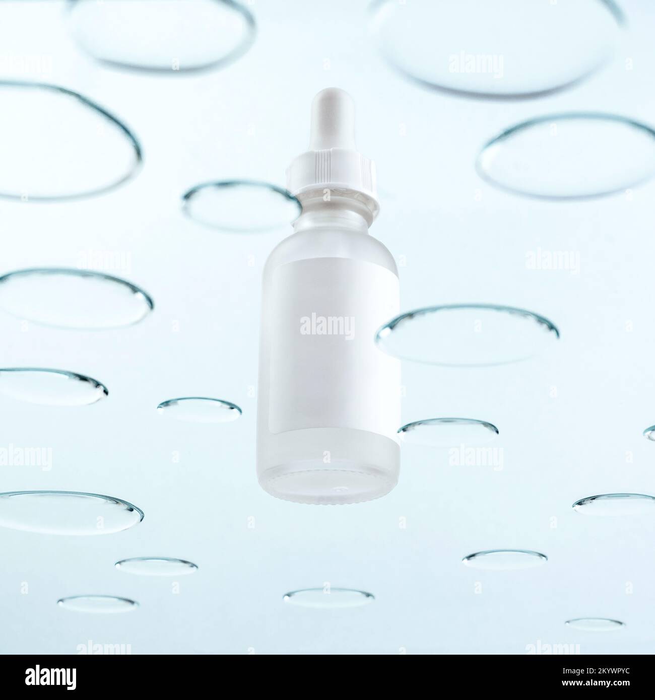 una bottiglia con una pipetta per cosmetici su fondo con gocce Foto Stock