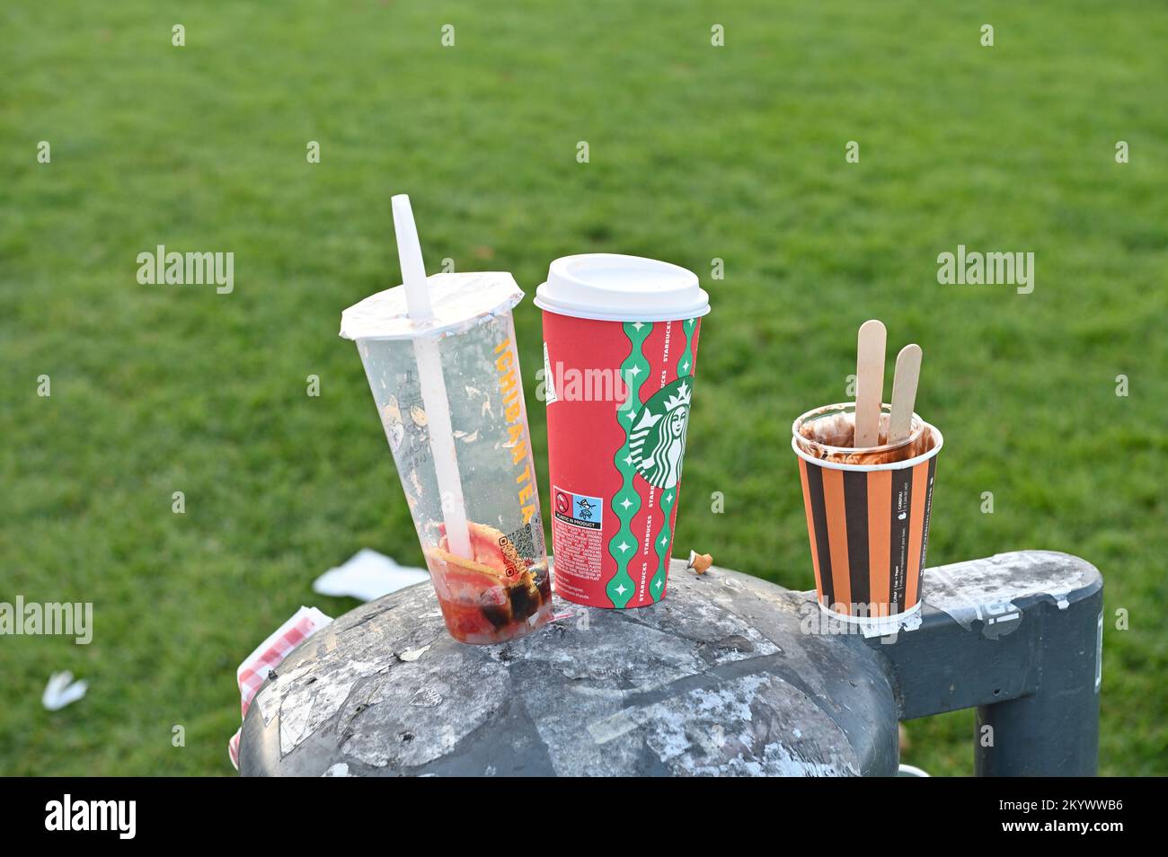 Svuotare le tazze da bere in un bidone dei rifiuti Foto Stock