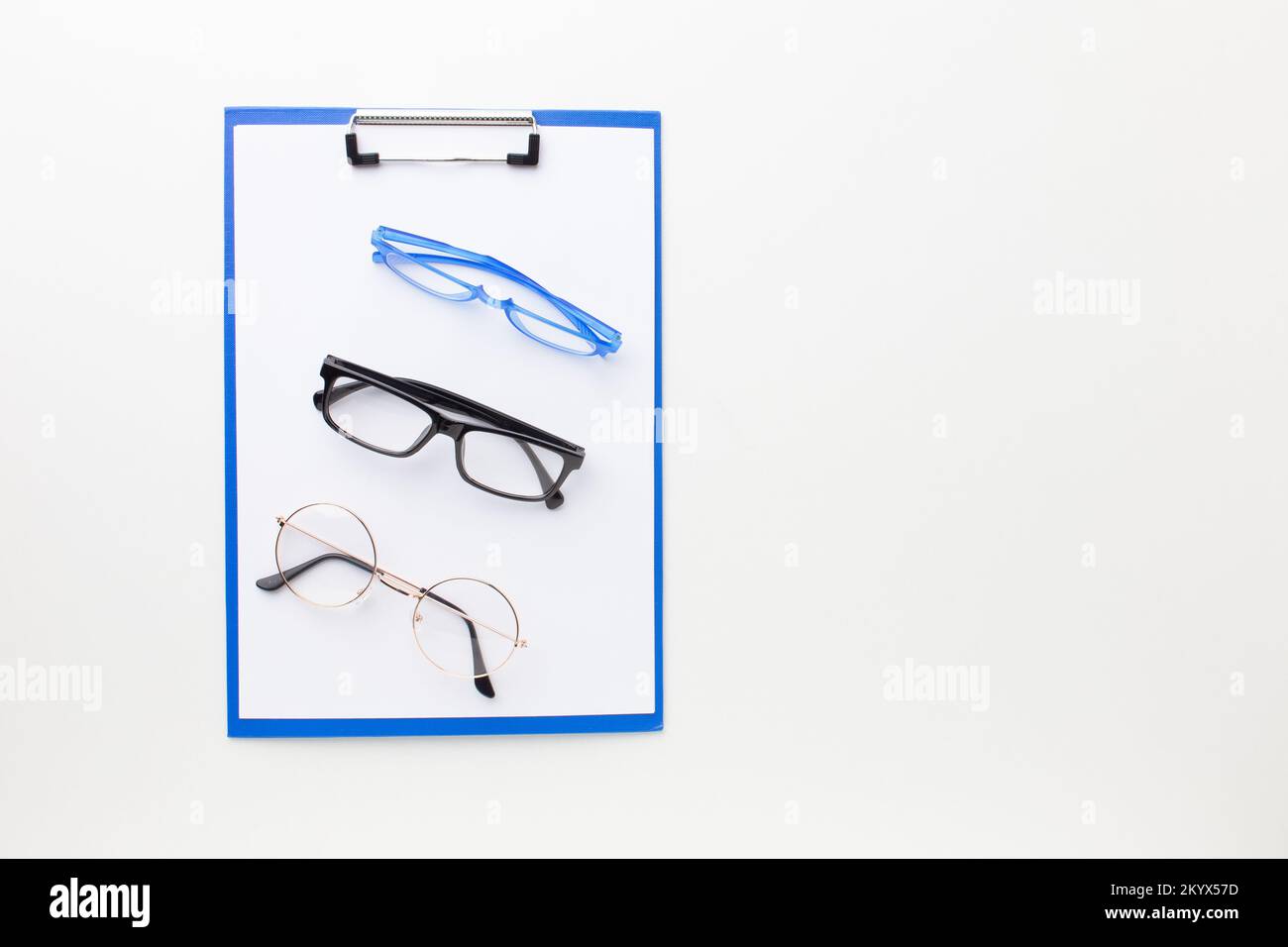 Molti occhiali diversi per la visione si trovano su una cartella per il testo. Foto Stock
