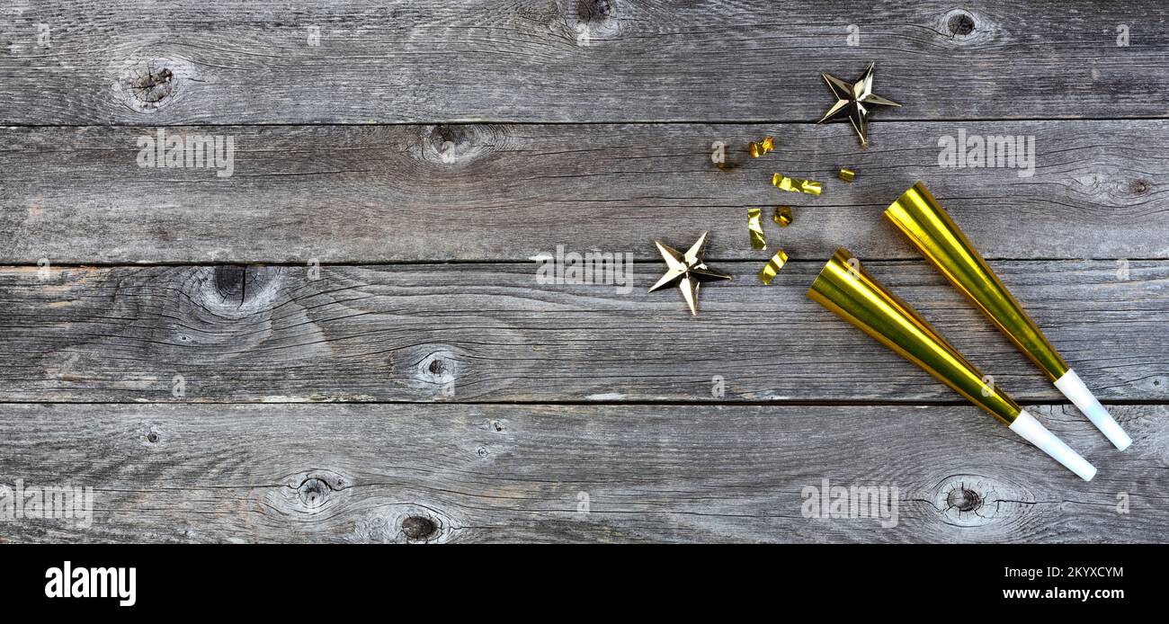 Sfondo festivo di Capodanno con noisemakers d'oro, stelle e confetti. Perfetto per altri eventi come Natale, compleanno o anniversario dell'annata Foto Stock