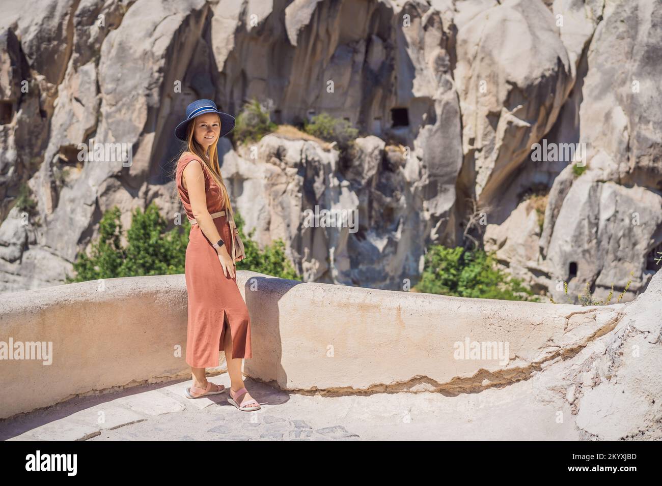 Giovane donna che esplora la valle con formazioni rocciose e grotte delle fate vicino a Goreme in Cappadocia Turchia Foto Stock
