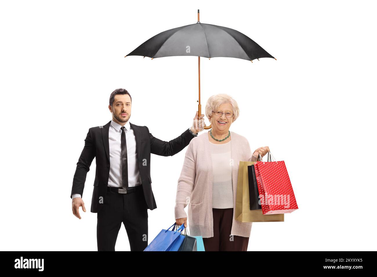 Bodyguard che tiene un ombrello per una donna anziana con borse per la spesa isolate su sfondo bianco Foto Stock