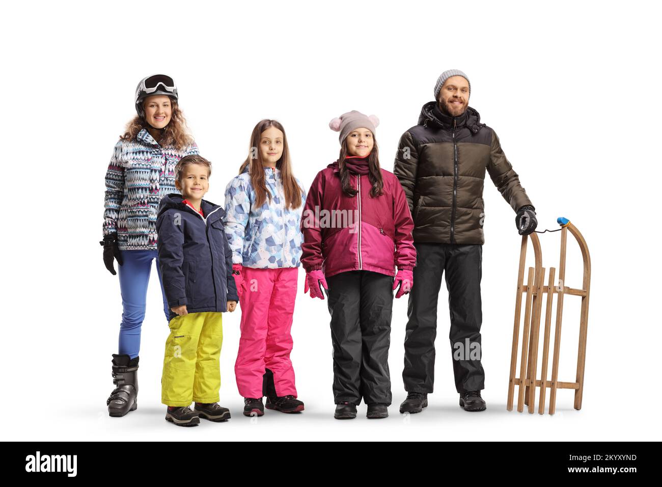 Giovane uomo e donna con bambini in abiti invernali posati con una slitta di legno isolata su sfondo bianco Foto Stock