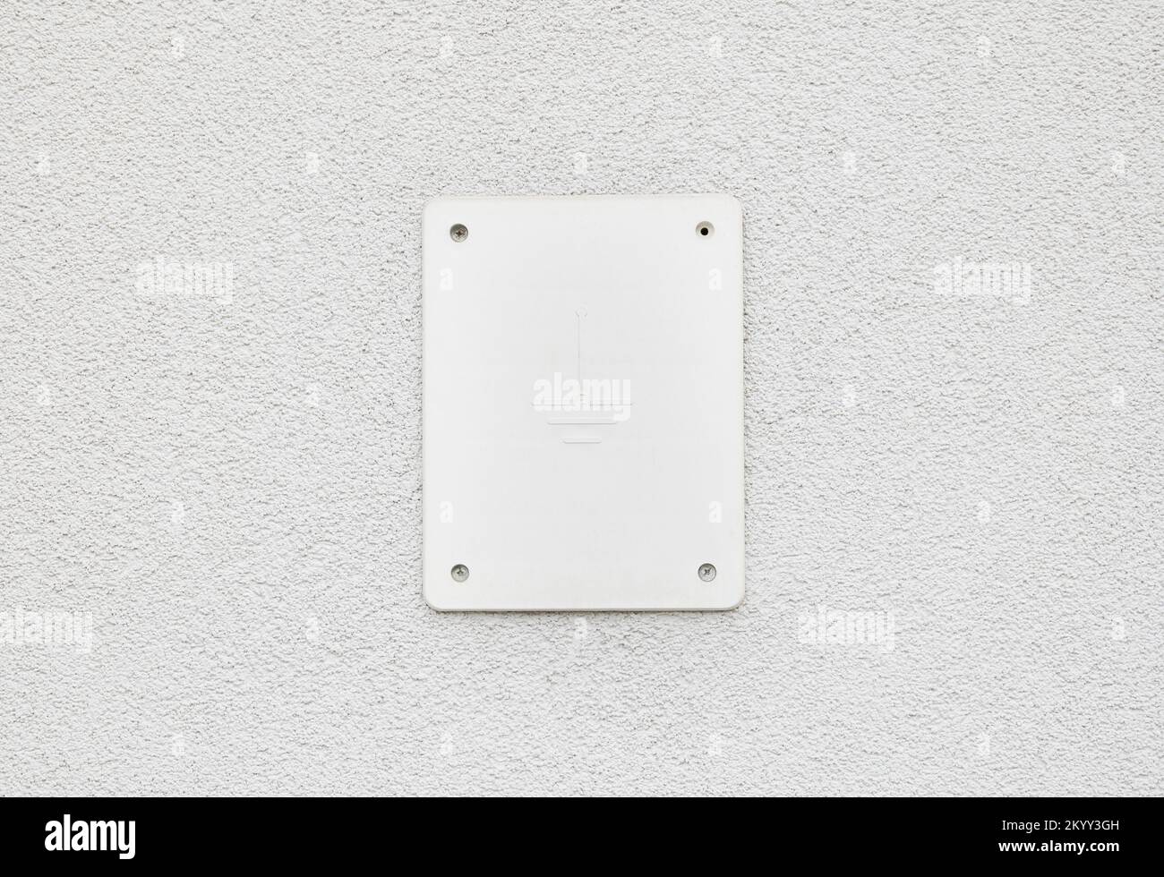 Piastra di copertura del cavo di messa a terra, simbolo sulla parete laterale di un edificio, cartello closeup, nessuno, nessuna persona. Elettricità, simboli elettrici, copertura del filo di massa Foto Stock