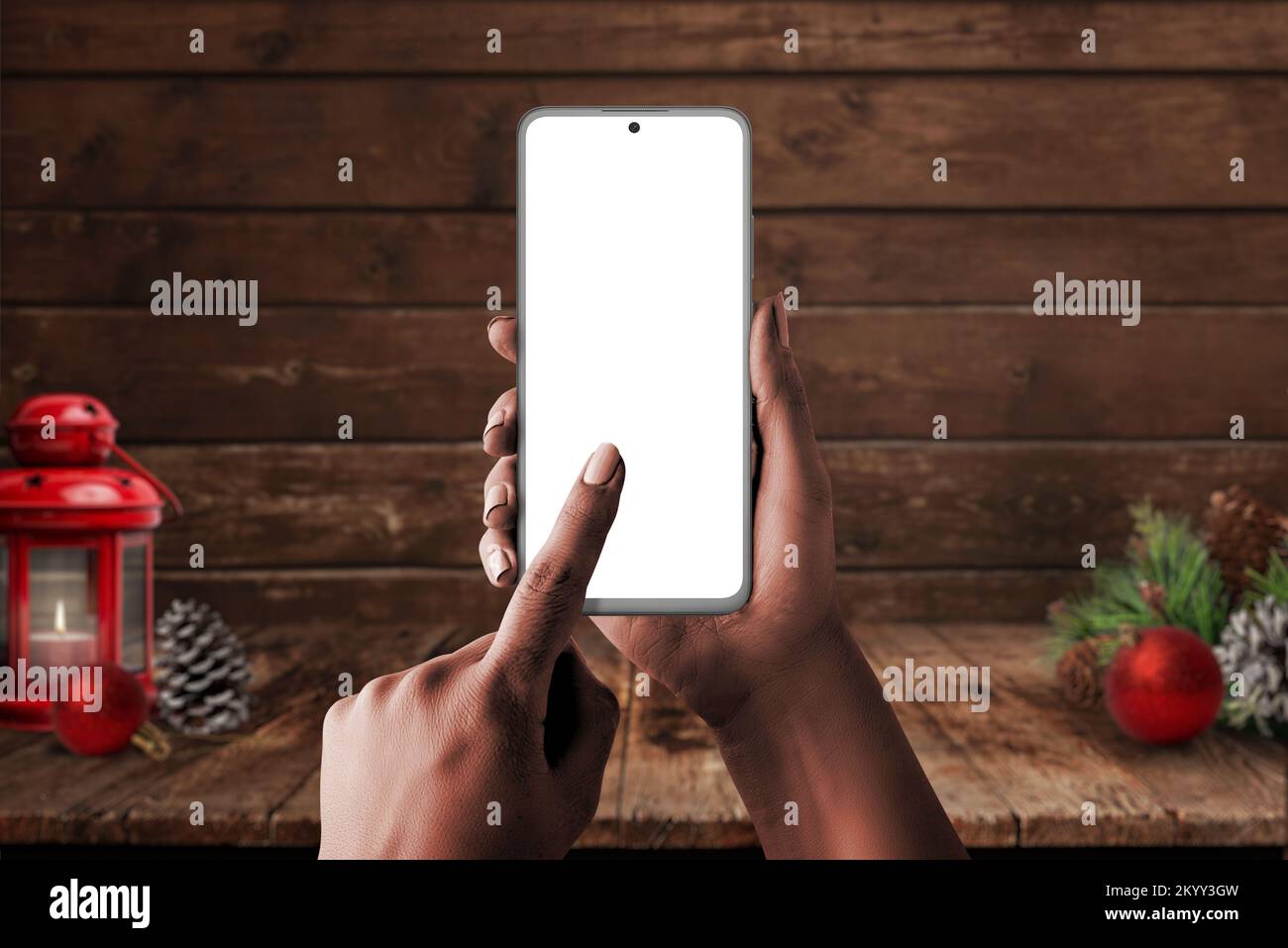 Telefono mockup in mano donna con decoratori di Natale in background. Schermata isolata per il messaggio di saluto o la promozione del prodotto Foto Stock