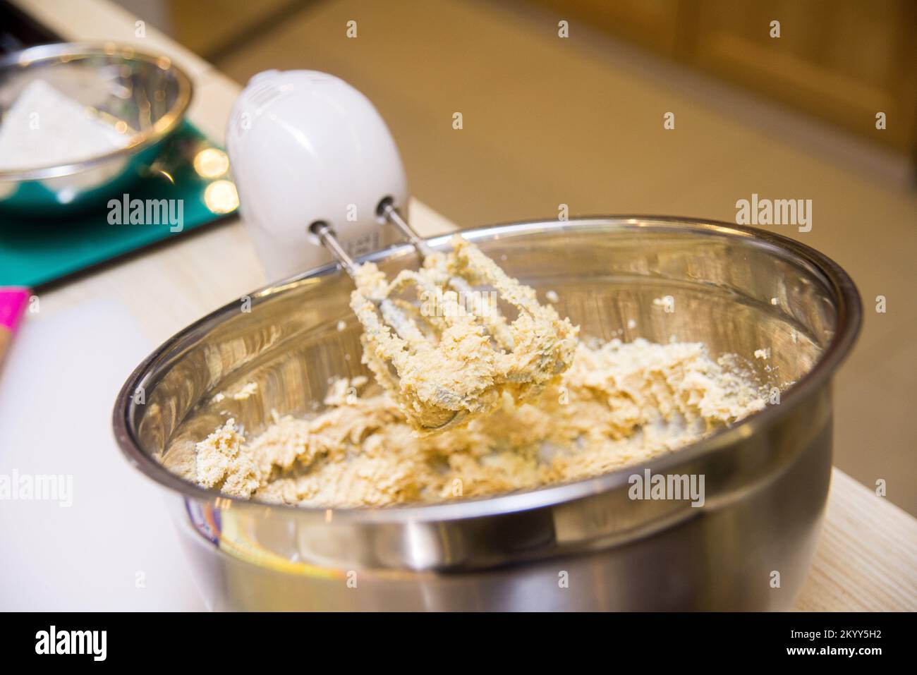 il mixer elettrico consente di impastare l'impasto in un recipiente di metallo profondo Foto Stock