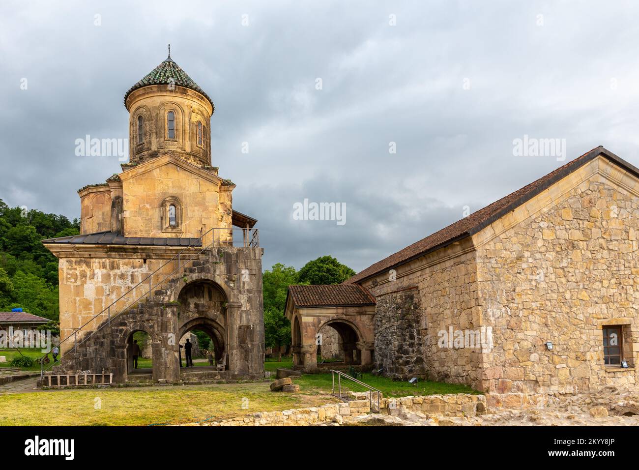 Campanile del Monastero gelati (campanile), complesso monastico medievale nei pressi di Kutaisi, Georgia fondato da re Davide IV, pareti in pietra con tetti in tegole verdi. Foto Stock