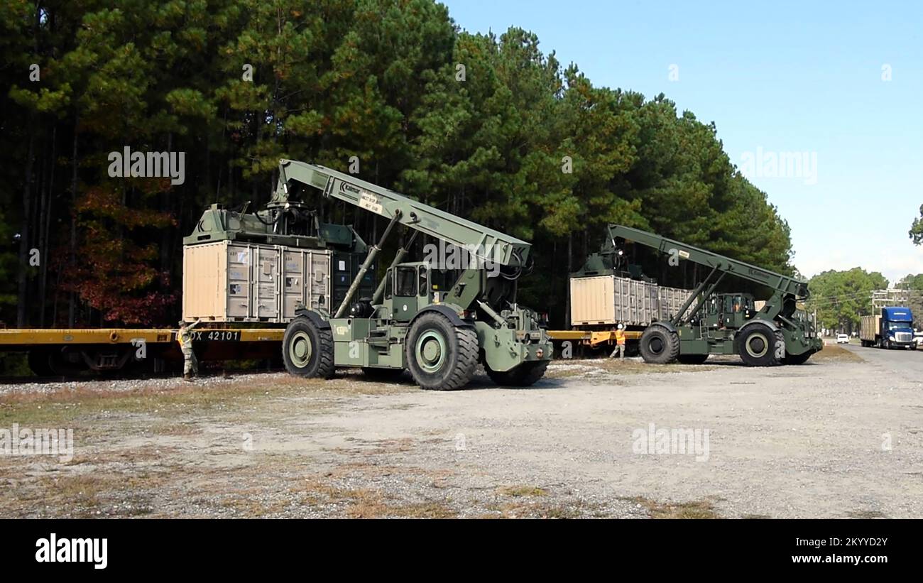 STATI UNITI I soldati con il Battaglione dei Trasporti 11th, la Brigata dei Trasporti 7th (spedizione), azionano i movimentatori di carichi Rough Terrain per caricare i container sui vagoni ferroviari presso la base comune Langley-Eustis, Virginia, 16 novembre 2022. I container sono riempiti di forniture che sosterranno la National Science Foundation della McMurdo Station, Antartide, che fa parte dell'operazione Deep Freeze. (STATI UNITI Foto dell'aeronautica di Abraham Essenmacher) Foto Stock