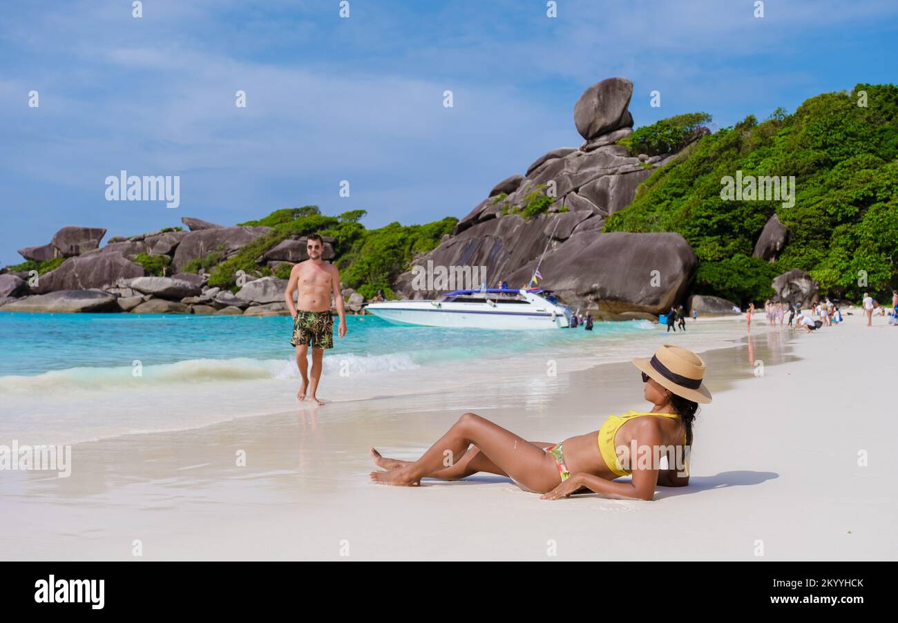 Donne nere e uomini bianchi che si rilassano sulla spiaggia al sole alle isole Similan in Thailandia Phannga Foto Stock