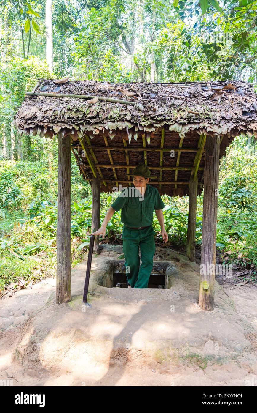 Ho Chi Minh City, Vietnam - 9 novembre 2022: I tunnel di Cu Chi vicino Saigon, famosa attrazione turistica in Vietnam. L'uomo in uniforme vietcong esce o Foto Stock