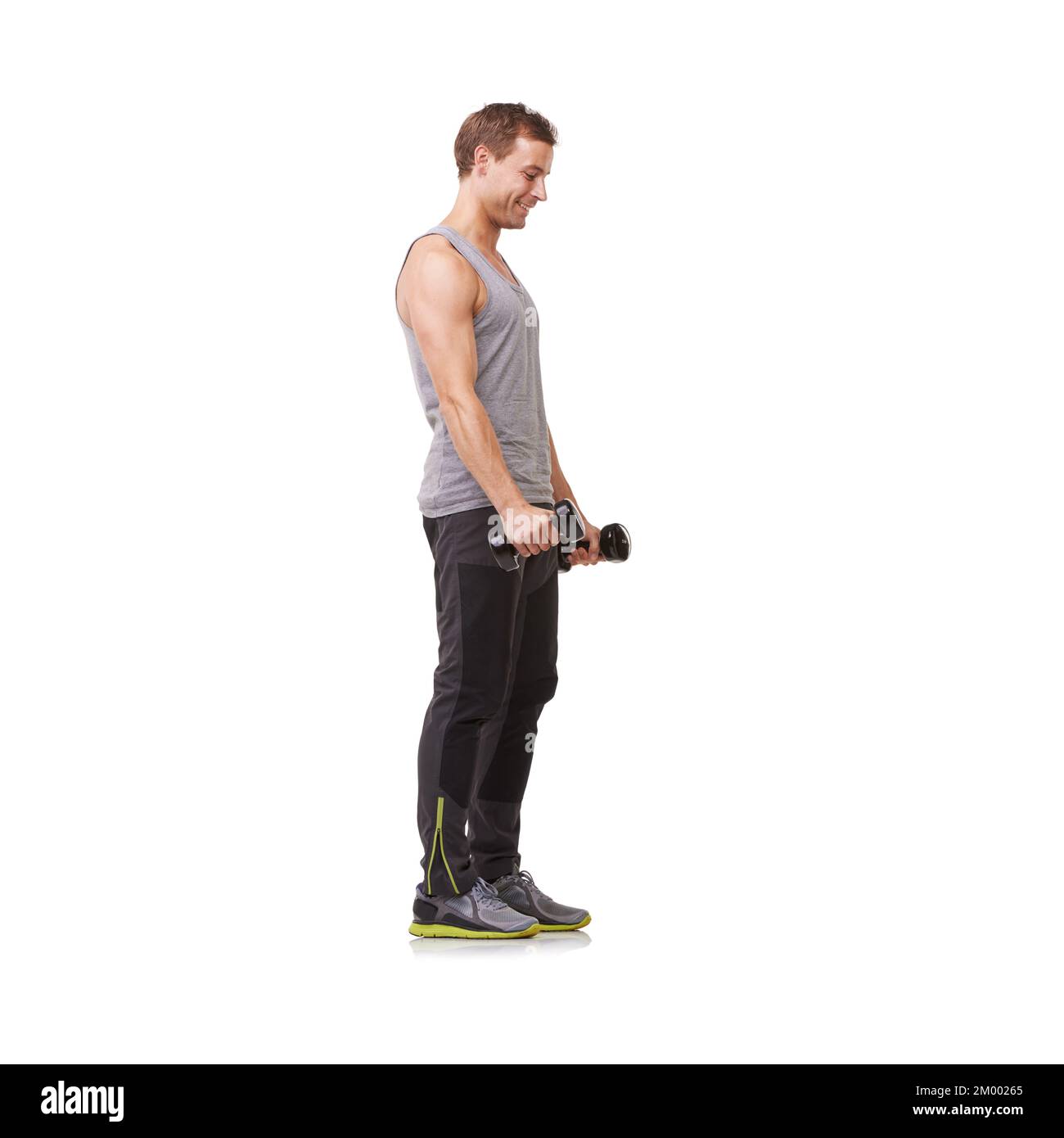 L'esercitazione lo eccita. Corpo intero di un giovane uomo in forma che fa ricci bicep mentre isolato su uno sfondo bianco. Foto Stock