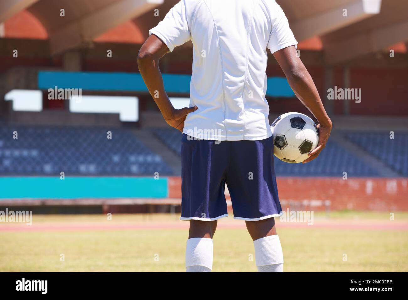 Pronti per la partita. Immagine retroguardia ritagliata di un giovane che tiene una palla da calcio. Foto Stock