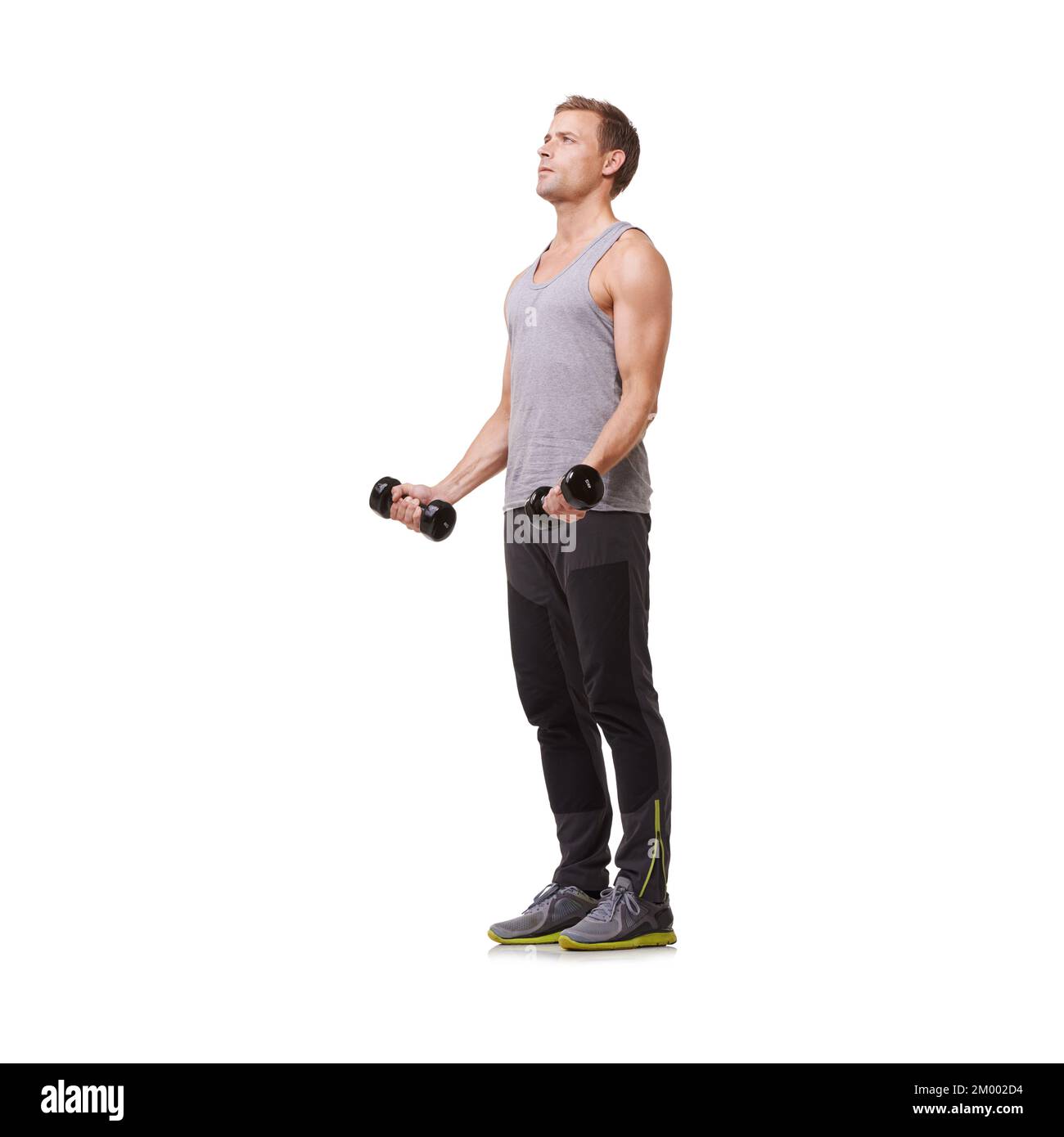Tonificare i suoi bicipiti. Corpo intero di un giovane uomo in forma che fa ricci bicep mentre isolato su uno sfondo bianco. Foto Stock