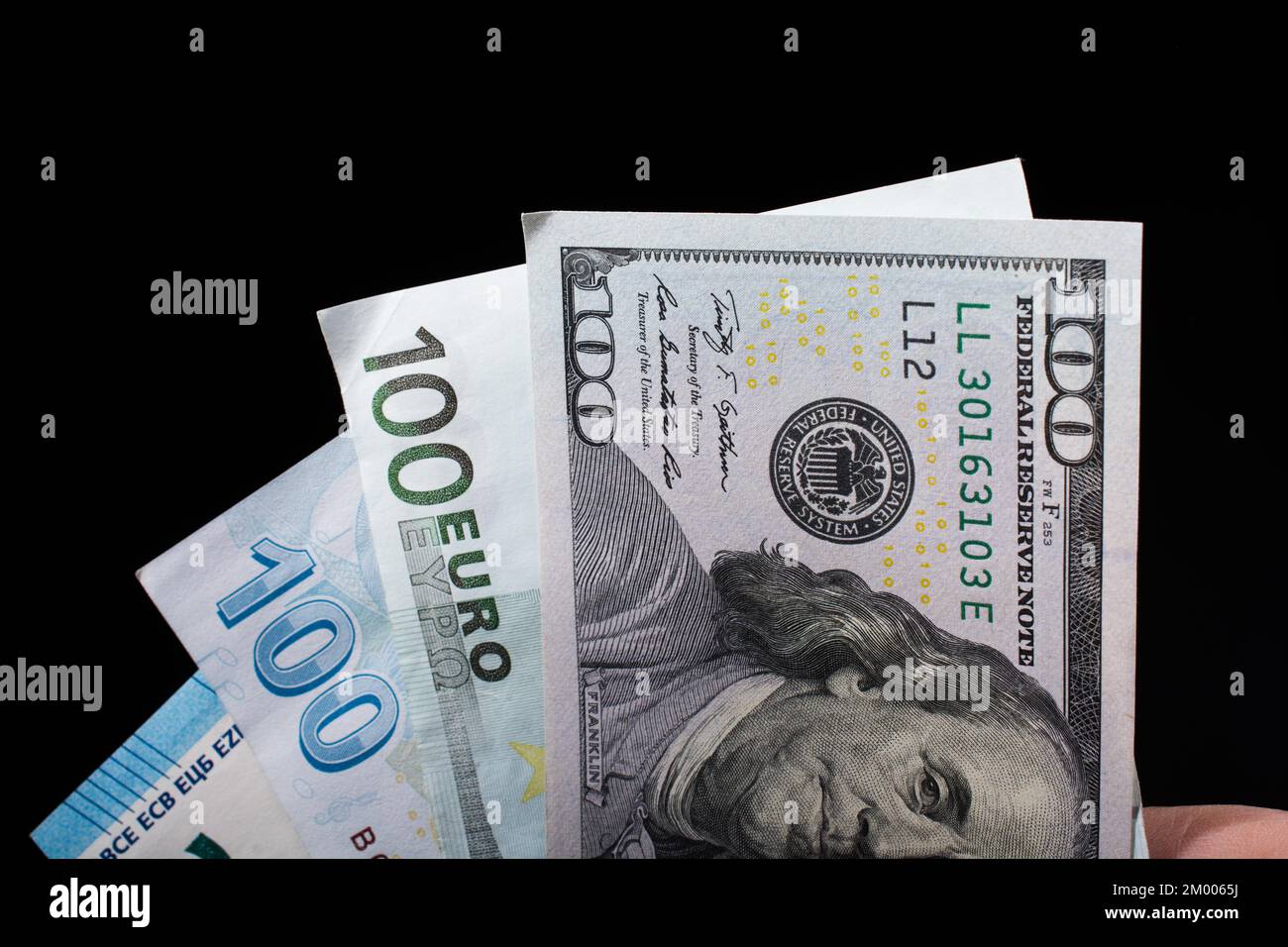 Tenere a mano le banconote in dollari americani isolate su sfondo nero Foto Stock